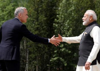 Canadian Prime Minister Mark Carney and Indian Prime Minister Narendra Modi hold hands before posing for a photo during the G7 Leaders' Summit in Kananaskis, Alberta. Credit: Reuters
